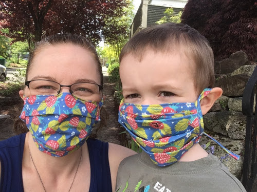 Julian and I posing with matching masks with a strawberry pattern.