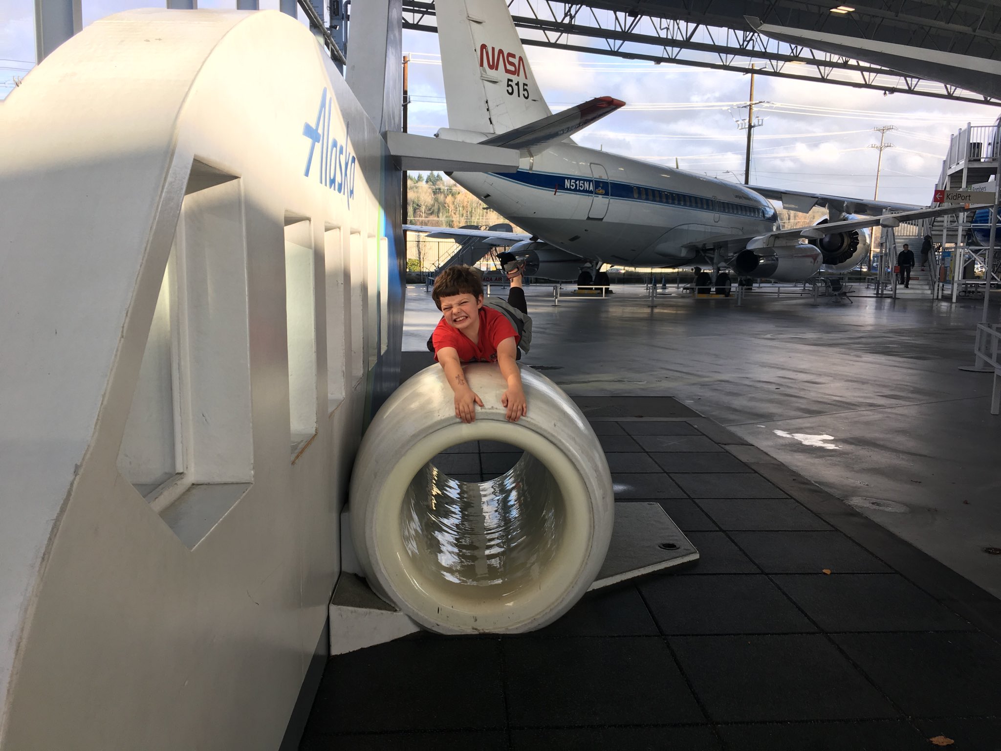 Calvin hanging onto the engine of a large pretend plane.