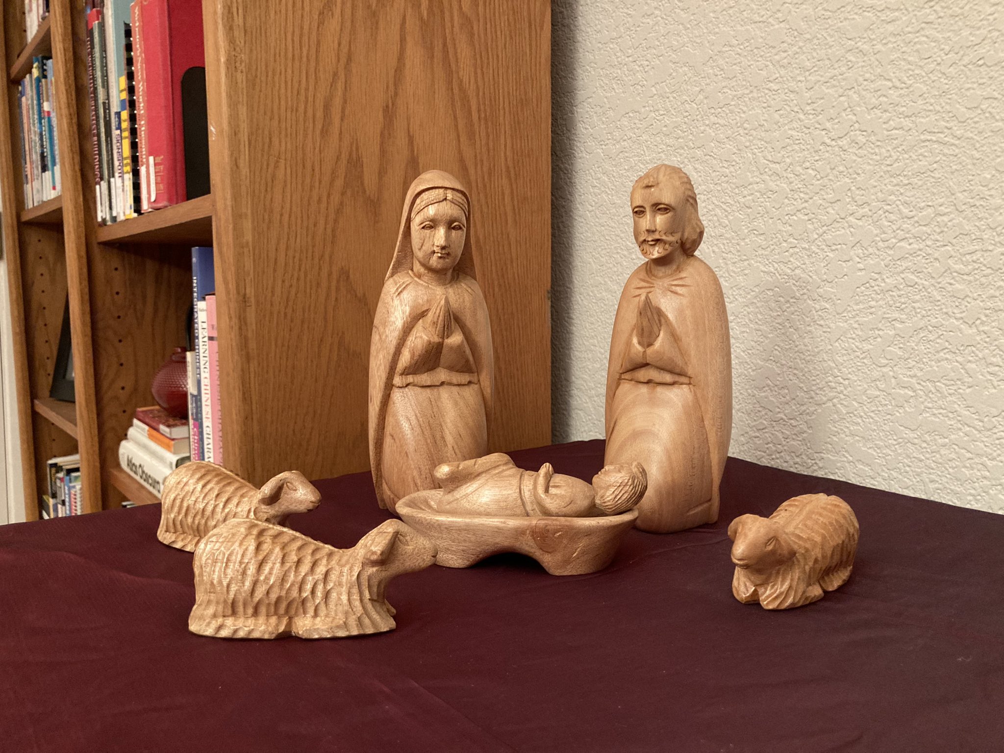 Wooden nativity with only Mary, Joseph, baby Jesus, and three sheep.