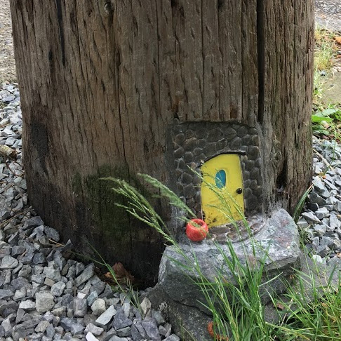 Yellow fairy door in utility pole.