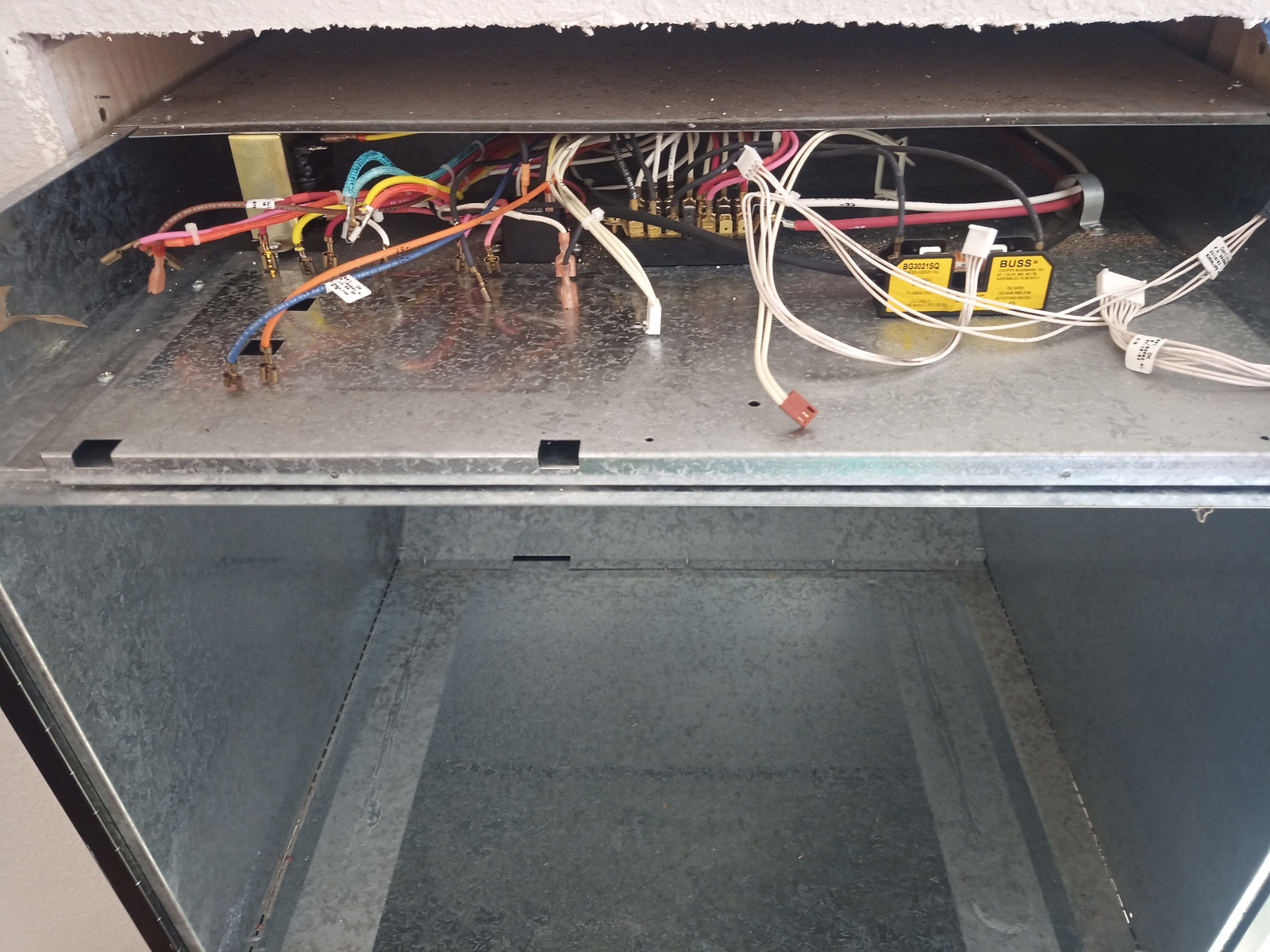 Loose wires haphazardly arranged on top of the oven frame.