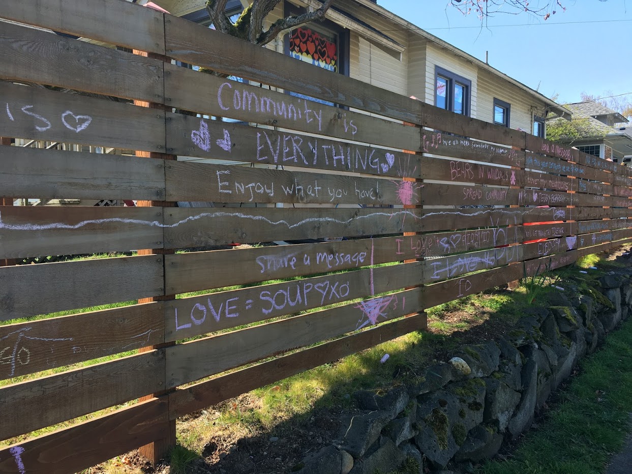 Fence with encouraging quarantine messages written in chalk.