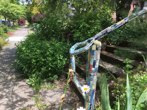 Stair handrail covered in mosaic tile.