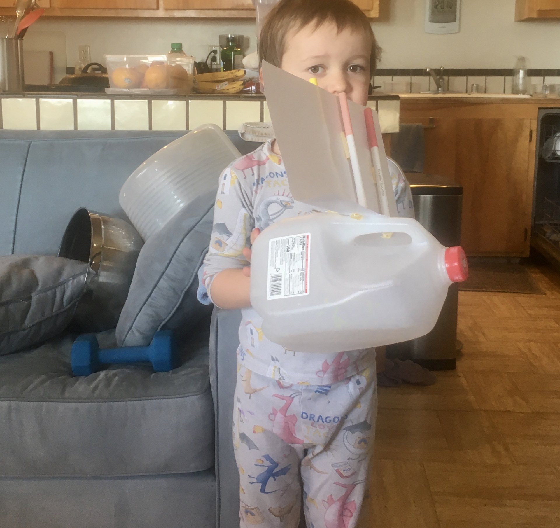 Julian holding a plastic milk jug which uses markers to prop up the sale made out of paper.