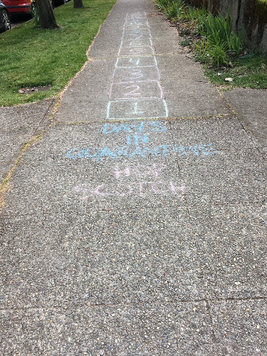 Sidewalk with chalk writing and numbered boxes.